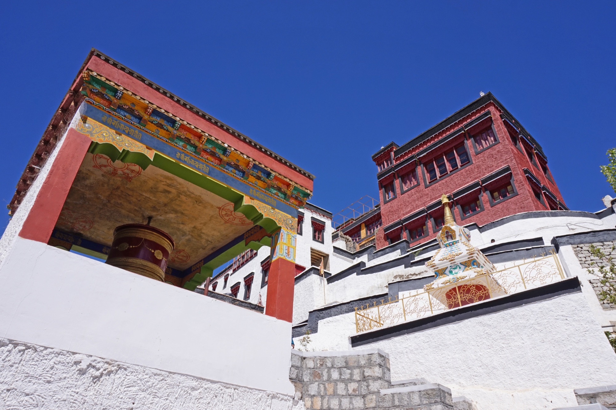 The painted eaves and prayer wheel of Thiksey monastery, Ladakh