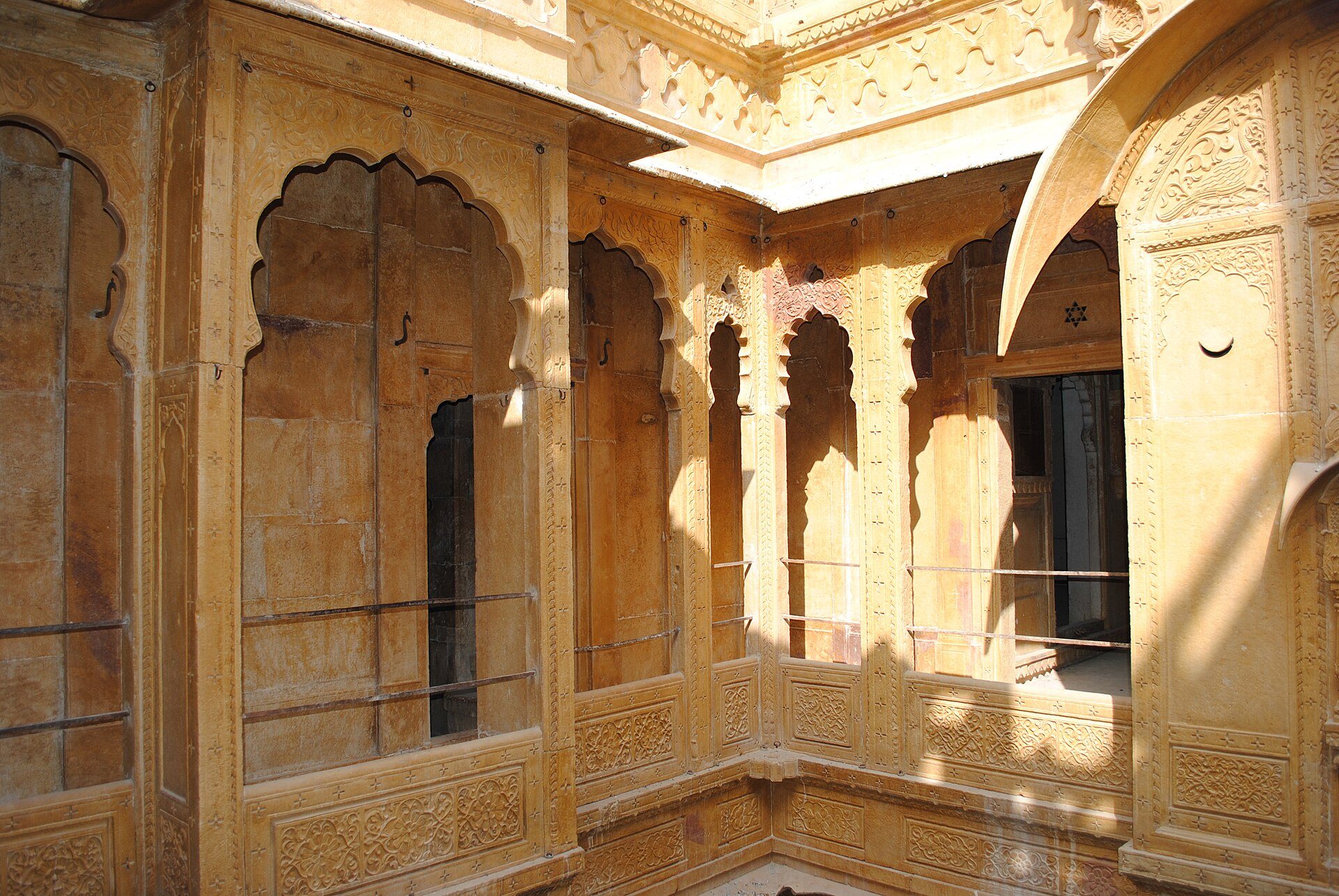 A sandstone haveli interior at Jaisalmer, arched niches cut into a thick wall