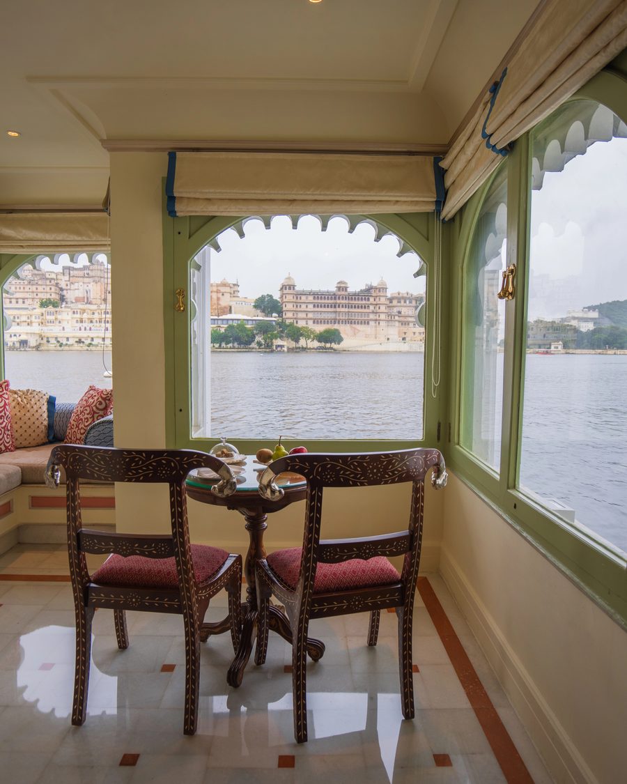 A private suite in the Taj Lake Palace, a table for two at the arched window with the City Palace across Lake Pichola