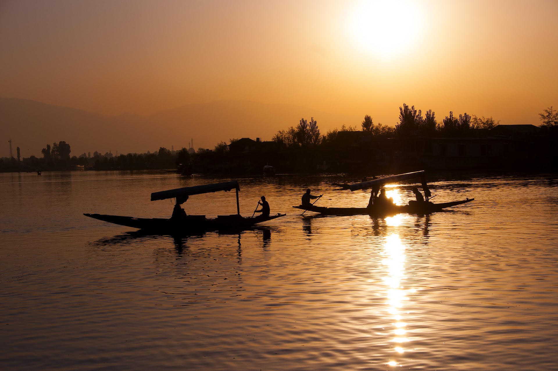 Golden sunrise over still water with a lone boatman